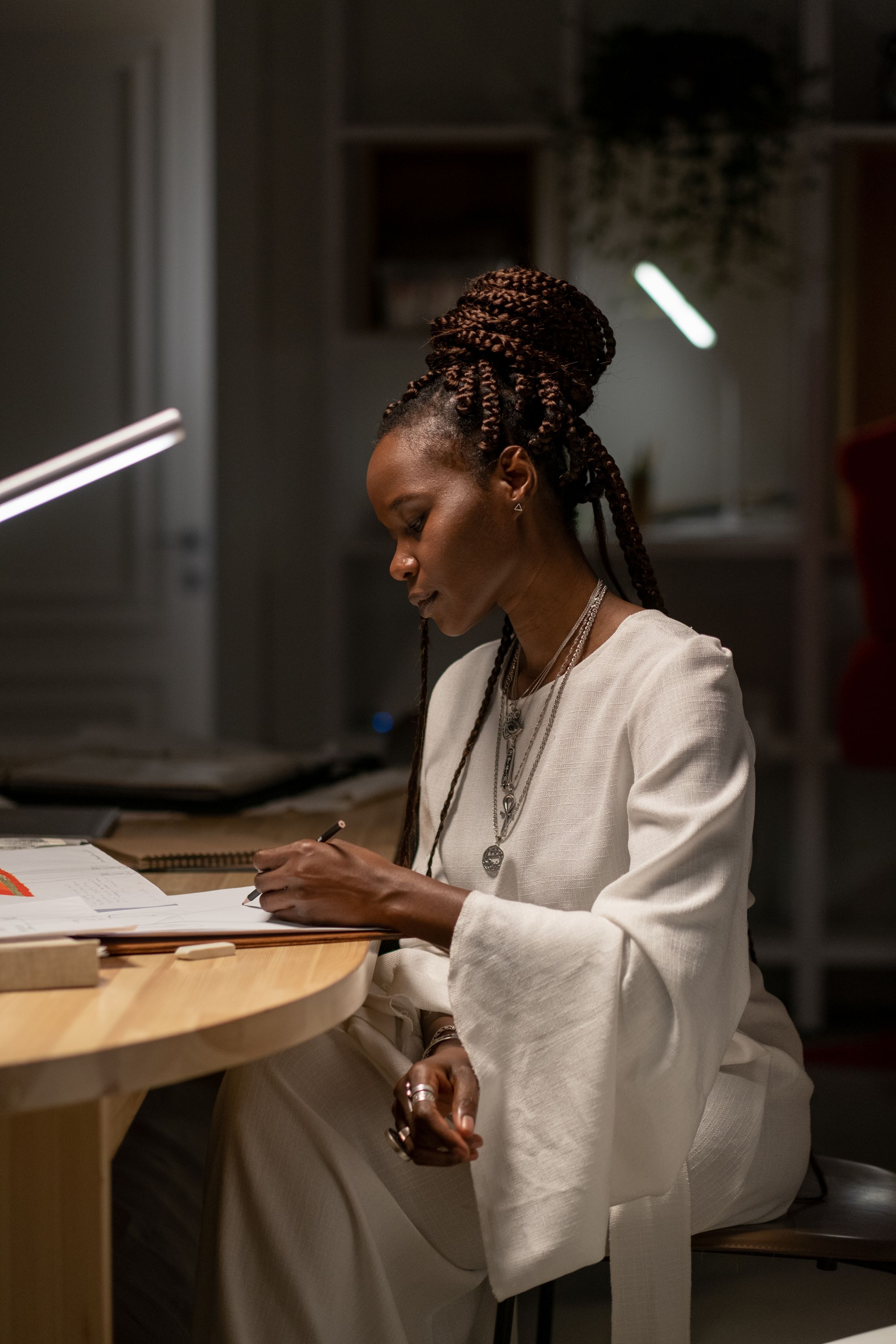 A fashion designer sketching ideas at a studio desk
