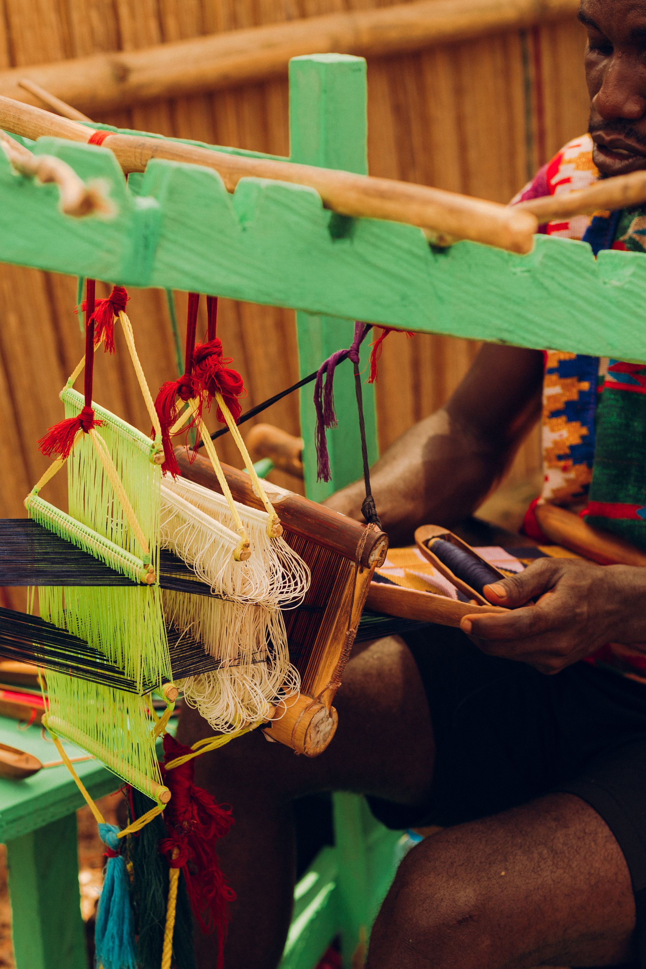 An artisan weaving colourful Kente cloth on a traditional loom in Accra