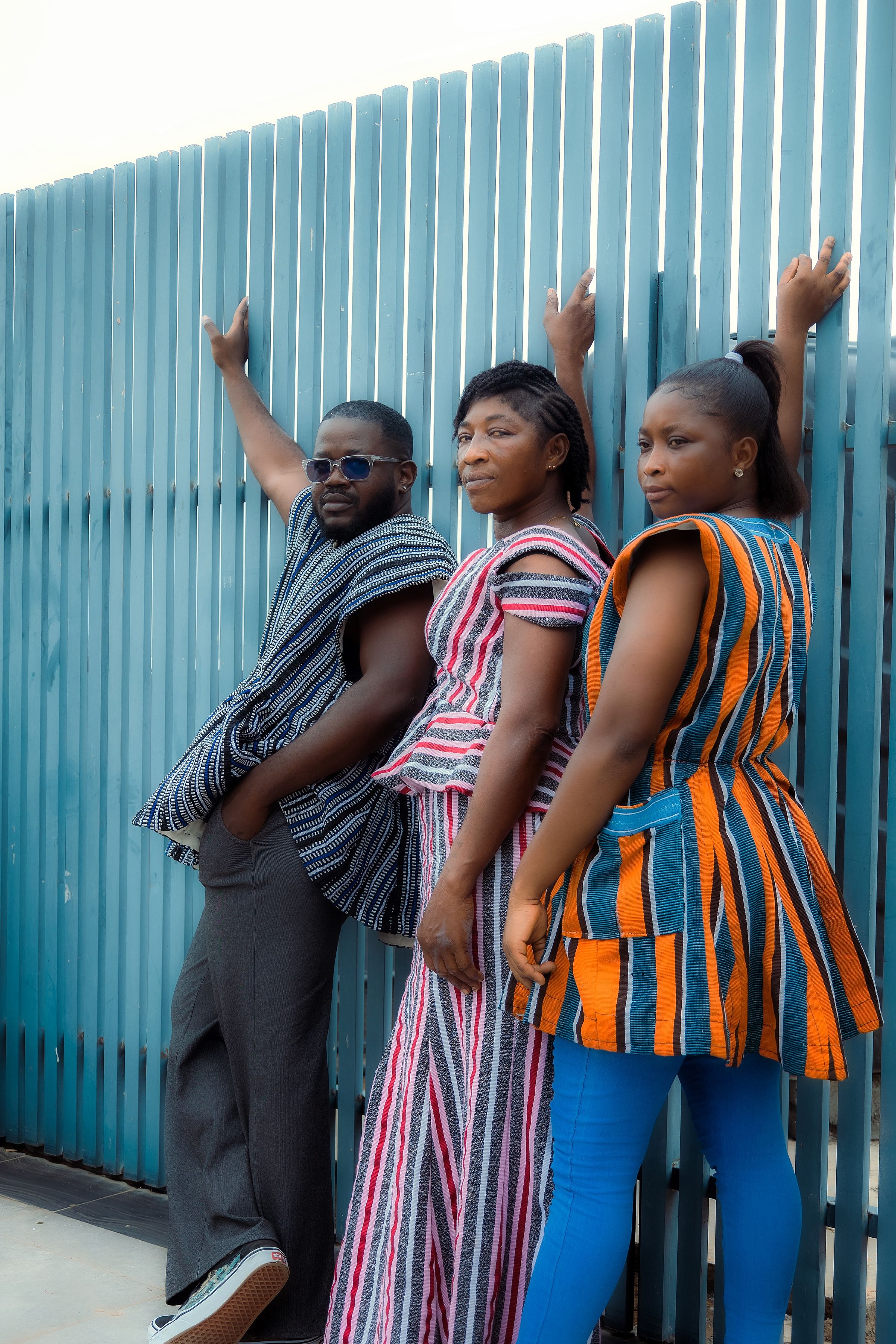 Three people wearing colourful traditional Ghanaian clothing in Accra